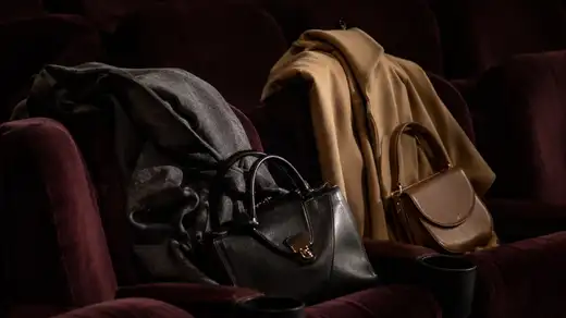 Cappotti e borse appese nel guardaroba di una sala cinema