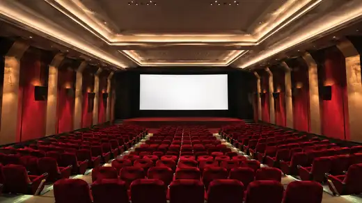 Vista panoramica di una sala cinema con file di poltrone rosse