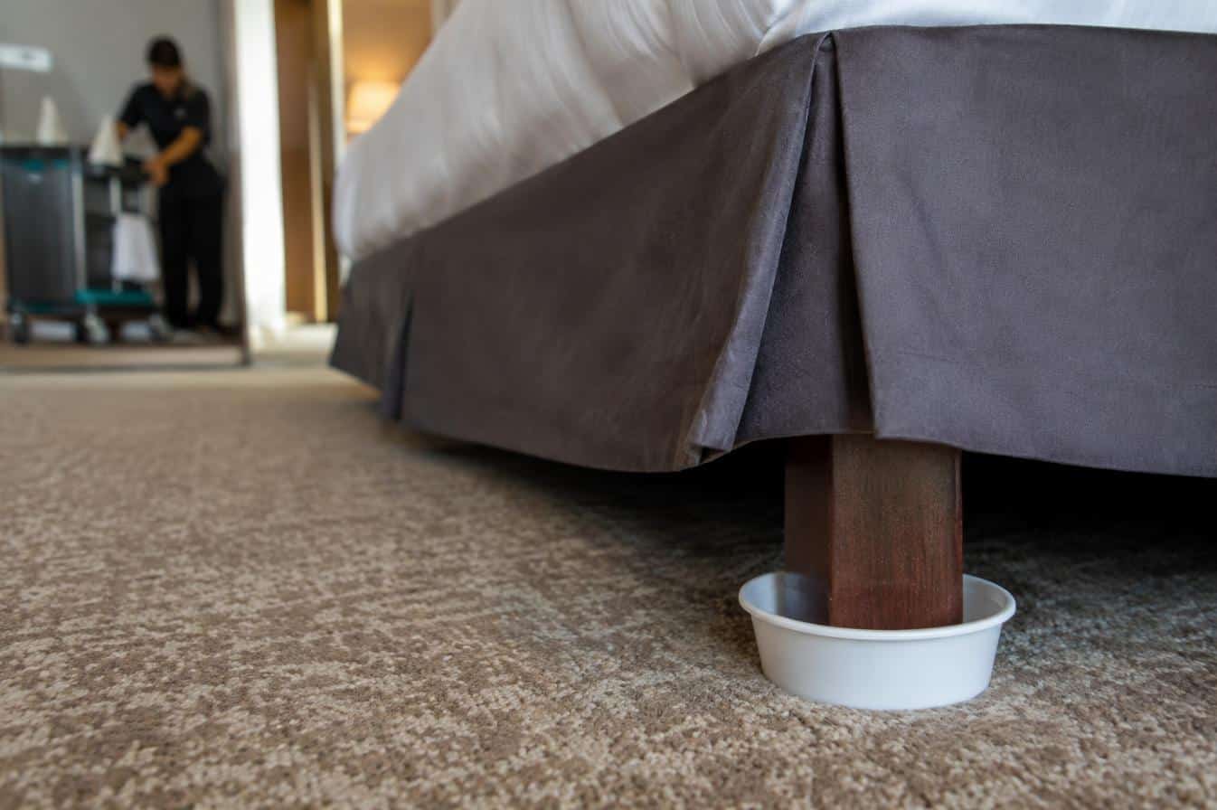 Trappola di monitoraggio sulla gamba del letto in una camera d’albergo: serve a misurare la presenza
