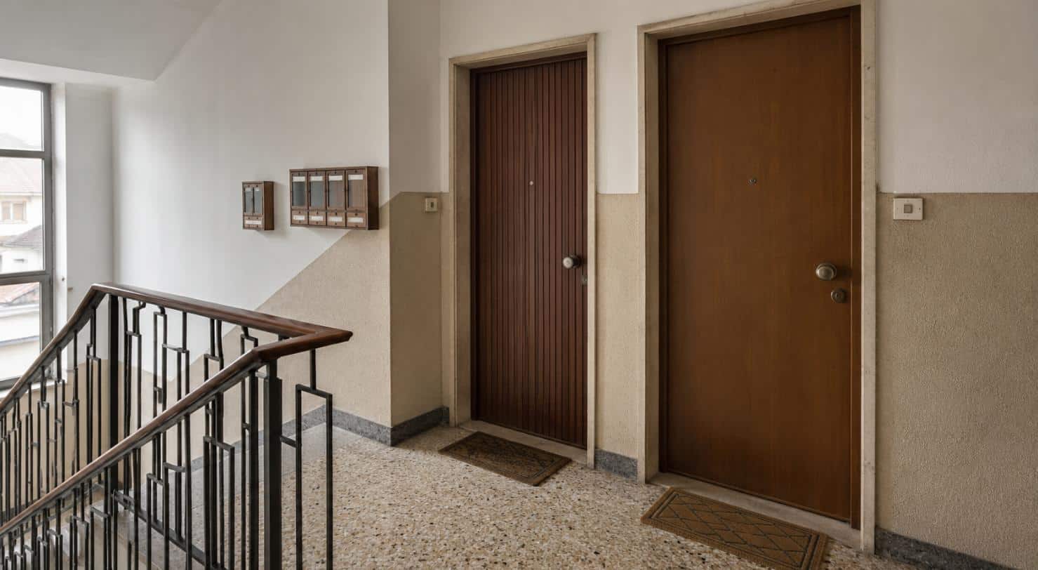 Pianerottolo condominiale con due porte affiancate: da qui le cimici dei letti passano fra appartamenti confinanti