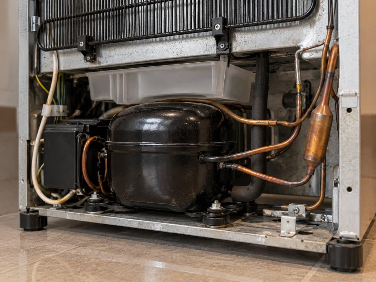 Vano basso sul retro di un frigorifero con il compressore e i tubi