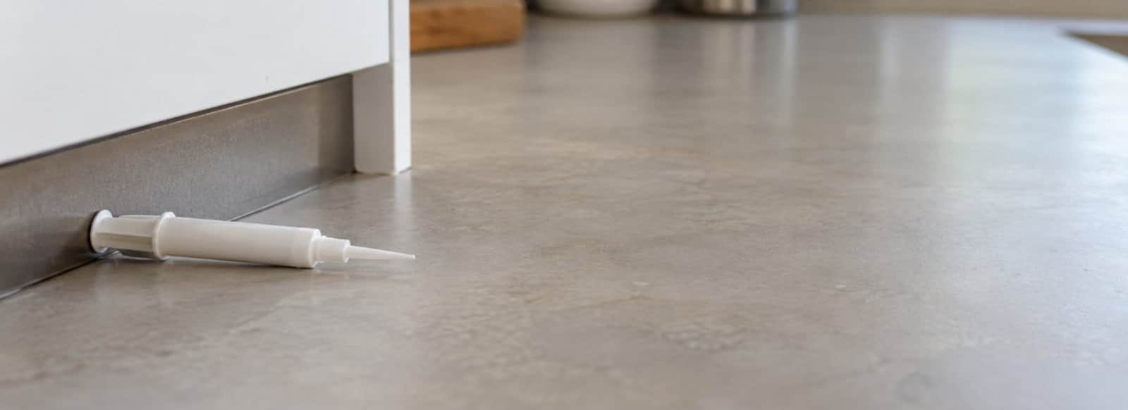 Siringa applicatrice di gel per scarafaggi appoggiata sul piano di una cucina
