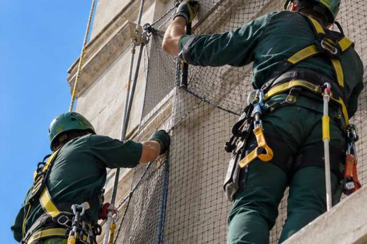 Tecnici Ekonore installano una rete anti volatili in facciata con imbracatura di sicurezza