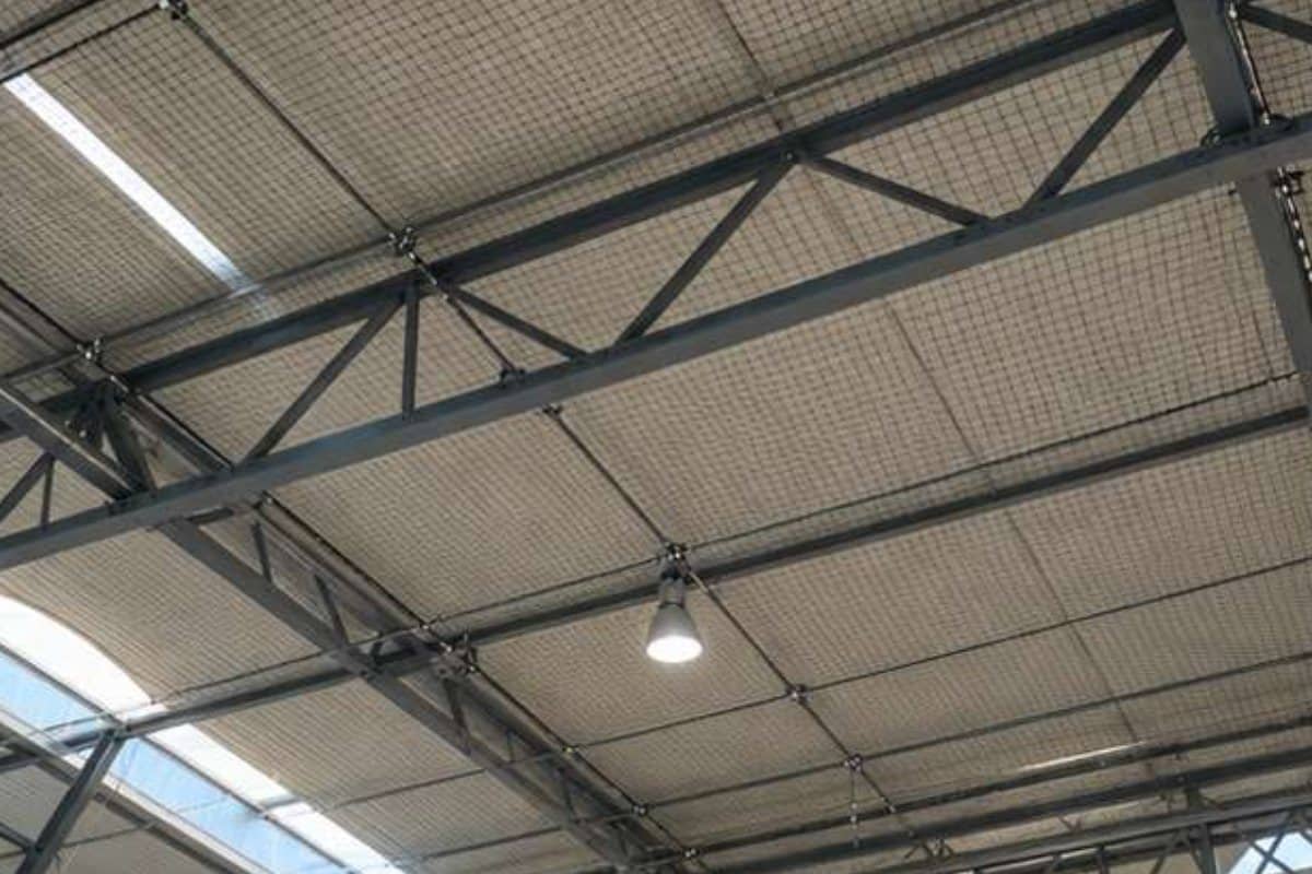 Rete anti volatili tesa sotto le capriate di un capannone industriale