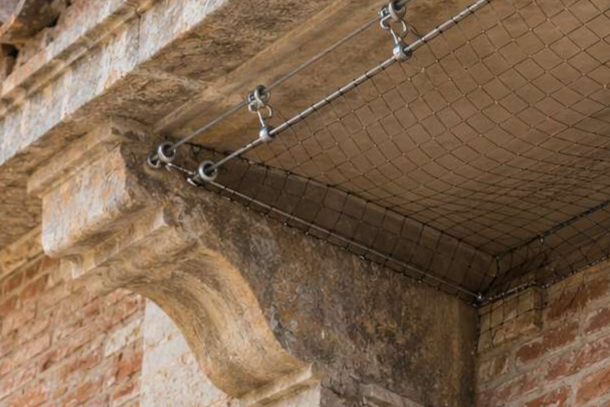 Rete anti volatili fissata sul cornicione di un palazzo storico