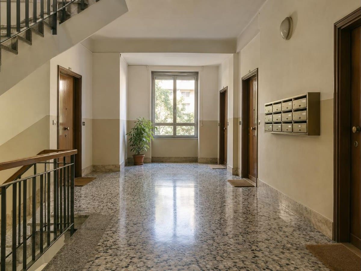 Pianerottolo di un grande condominio a Roma con pavimento in graniglia e cassette postali