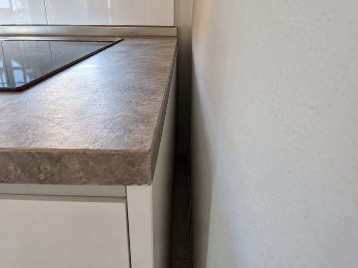 Spazio stretto e scuro tra il piano cucina e il muro in una cucina vuota