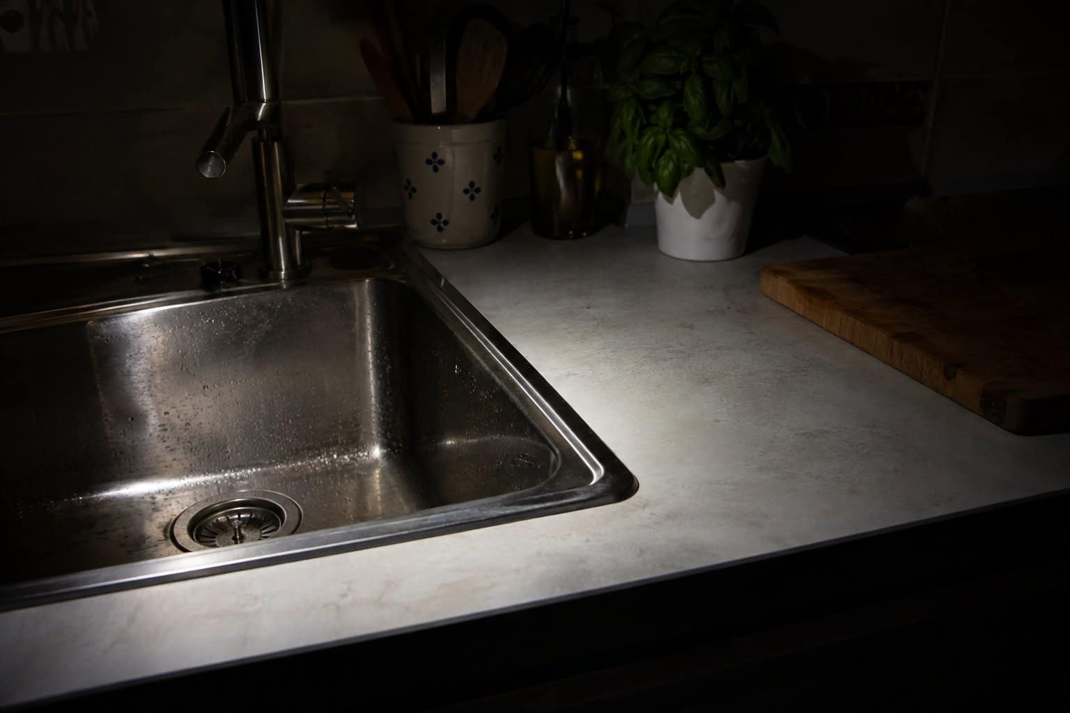 Bordo del lavello e piano cucina illuminati dalla luce di una torcia