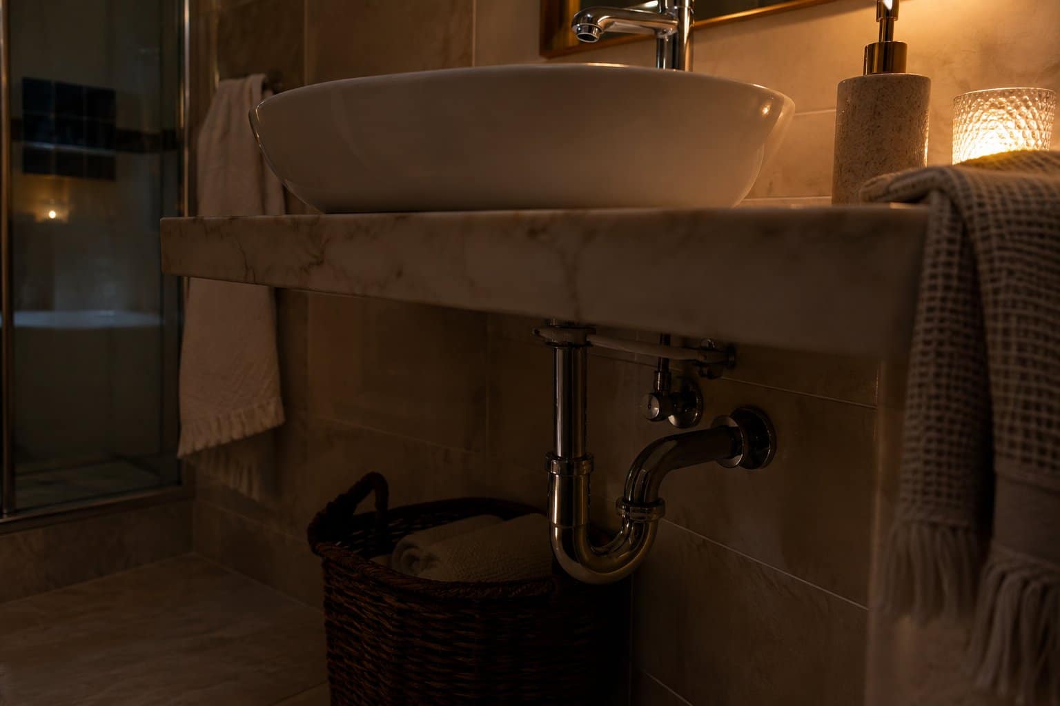 Sifone e scarico del lavabo di un bagno con luce bassa