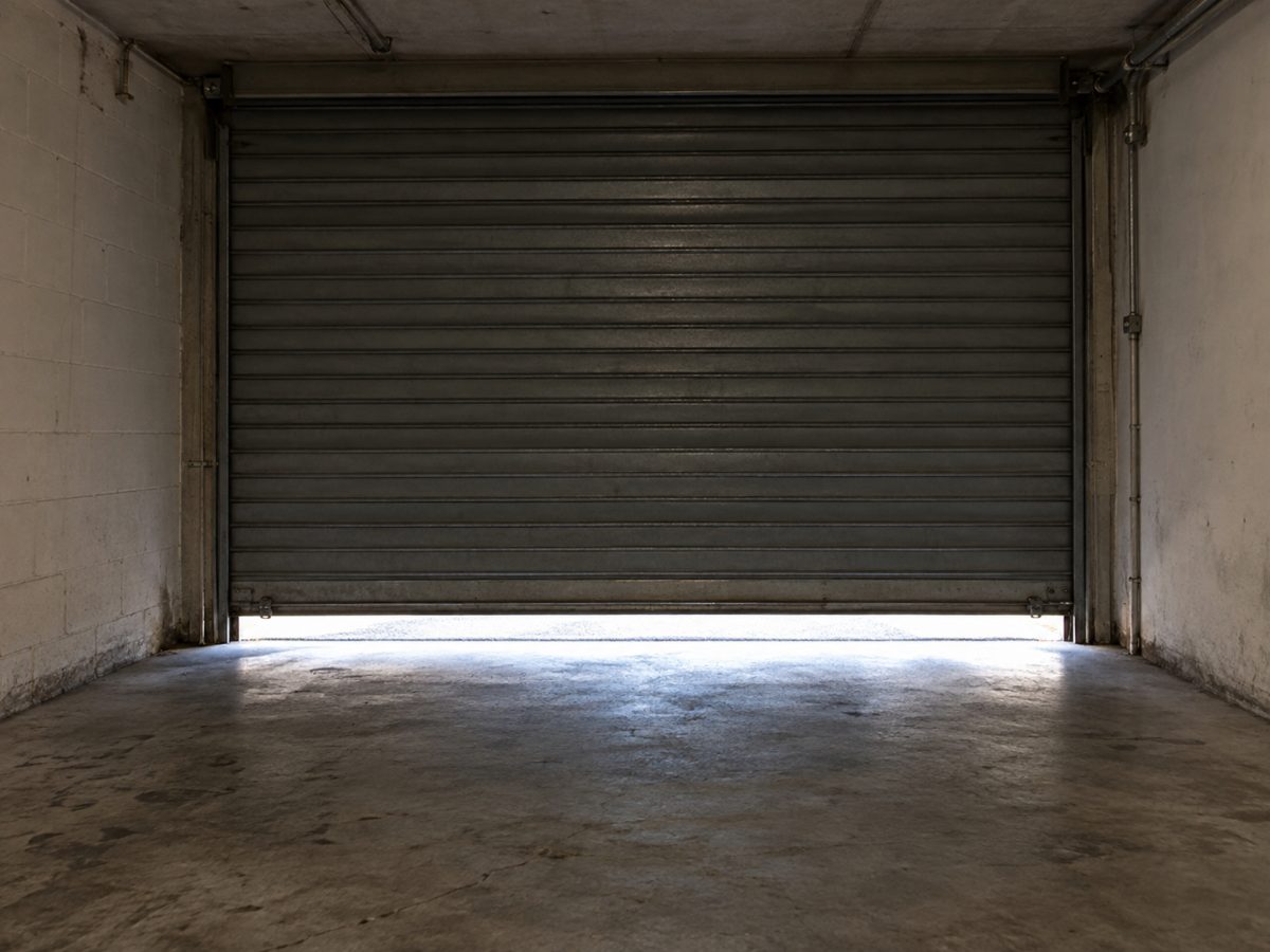 Garage condominiale con serranda abbassata e una fessura di luce in basso