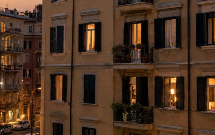 Facciata di un condominio italiano di sera con finestre illuminate