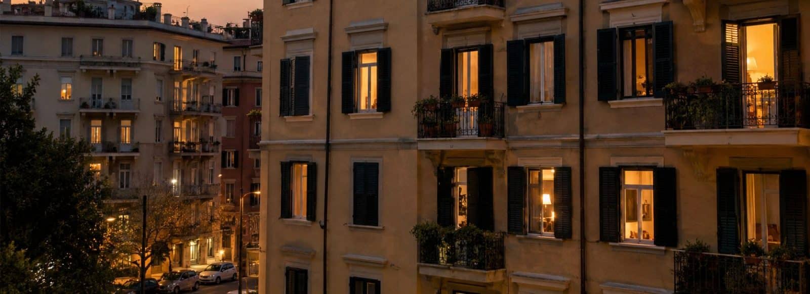 Facciata di un condominio italiano di sera con finestre illuminate